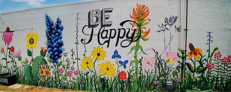 The "Be Happy" mural ... on the back wall of the ETX Brewing Company, facing South College Avenue